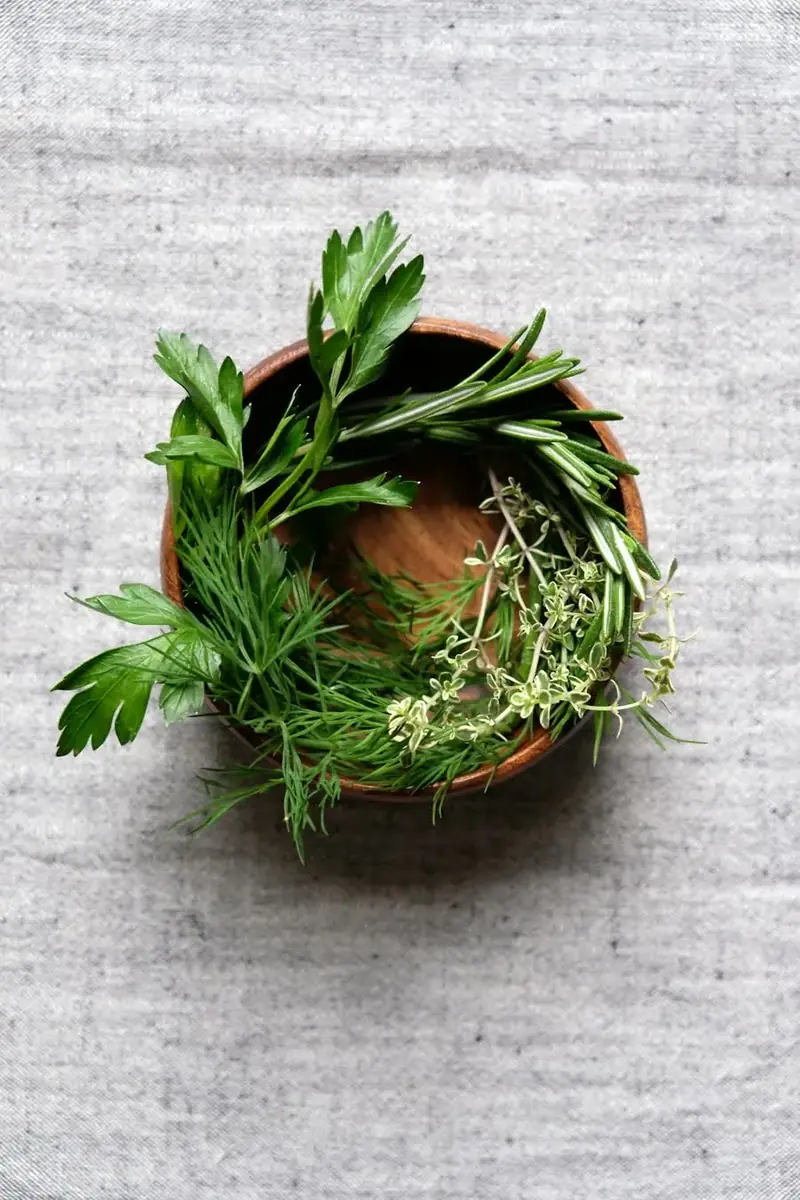A wooden bowl of fresh herbs