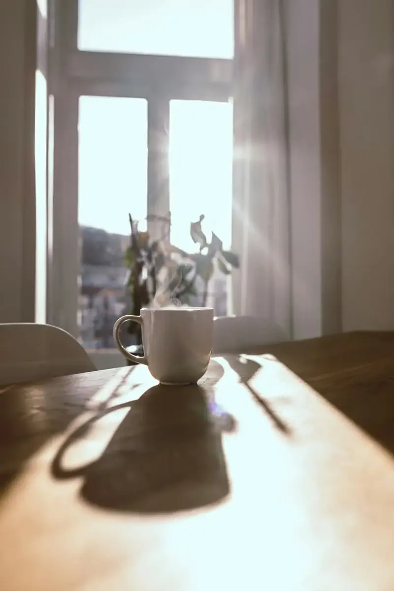 A cup of tea on a table in early morning light